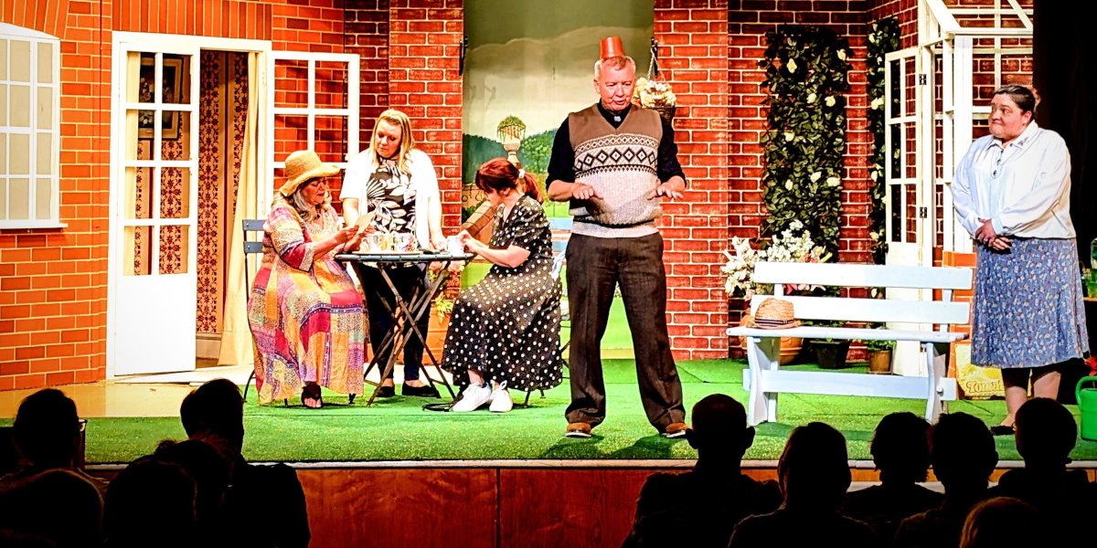 A scene from Brightlight Theatre's production of Entertaining Angels. A man wears a plant pot as a fez like hat.