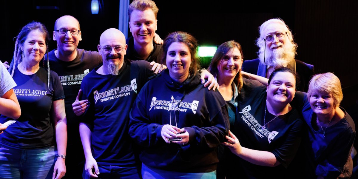 The cast and crew of Brightlight Theatre's production of Songkeeper being presented with the award for winning Woking Festival.